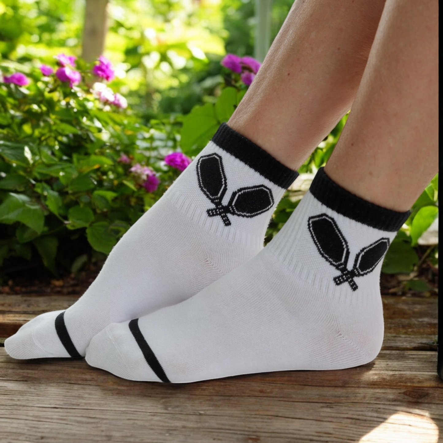 White quarter crew socks with black stripes and black pickleball paddles.