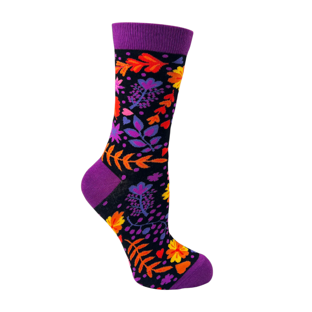 Women’s floral print crew sock with purple cuff on black background featuring bright flowers, leaves, and small heart accents.