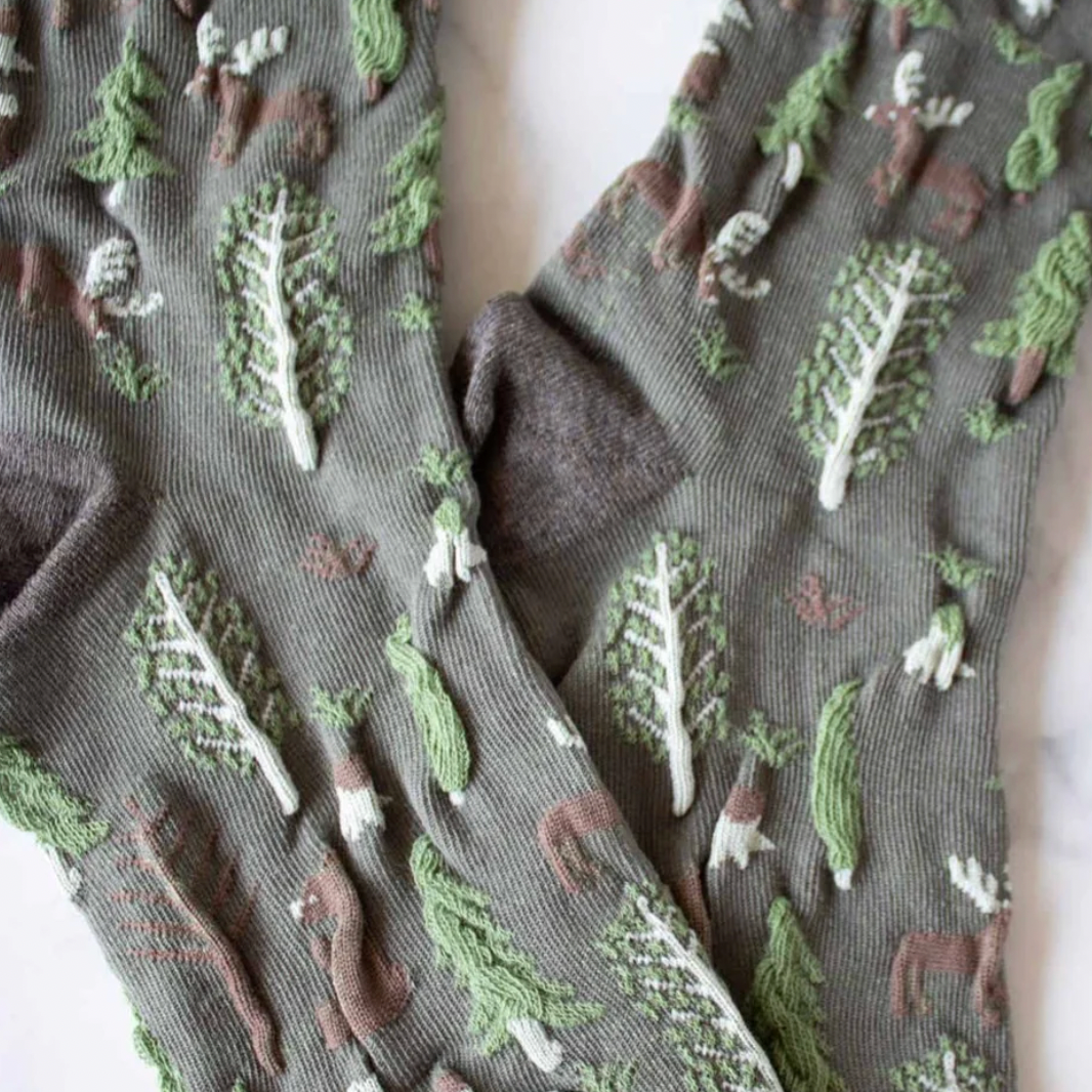 Women's olive crew socks with woodland winter theme of pine trees, moose, bears in olive green with textured, brown, green and brown accents