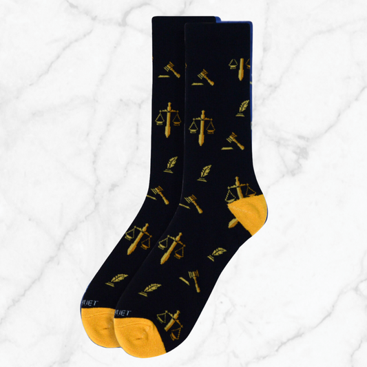 Pair of black lawyer-themed socks featuring gold scales of justice, quill, and gavel symbols, designed for legal professionals and bar exam candidates.