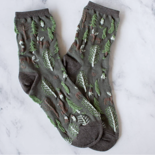 Women's olive crew socks with woodland winter theme of pine trees, moose, bears in olive green with textured, brown, green and brown accents