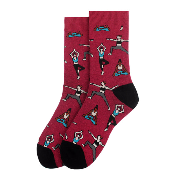 A pair of red socks featuring illustrations of people in various yoga poses. The socks have black toes and heels and showcase characters practicing yoga in diverse positions such as tree pose, warrior pose, and seated meditation.